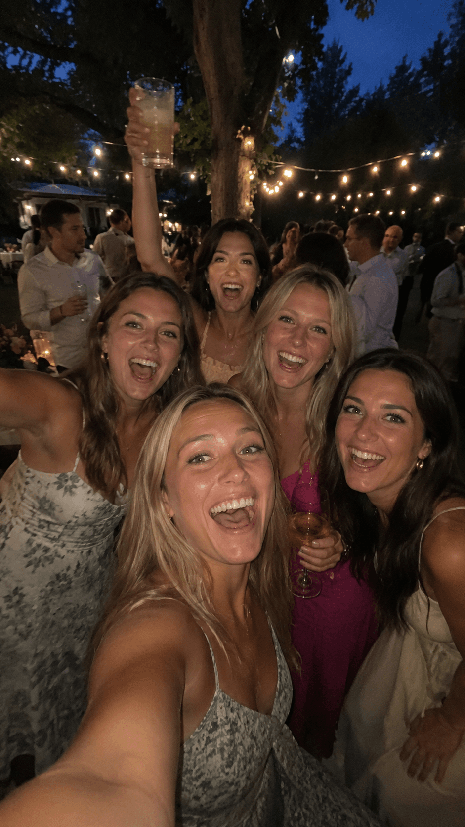 A group of friends taking a selfie at an evening celebration