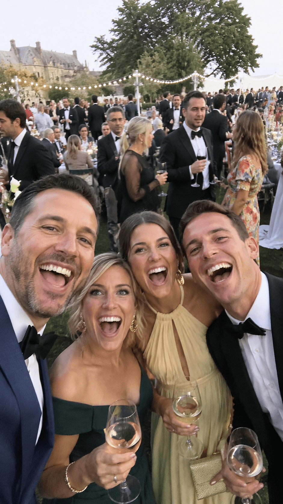 Wedding guests laughing together at an outdoor reception